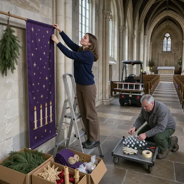 a person hanging Advent banners on the wall of a stone church nave surrounded by boxes of seasonal decorations